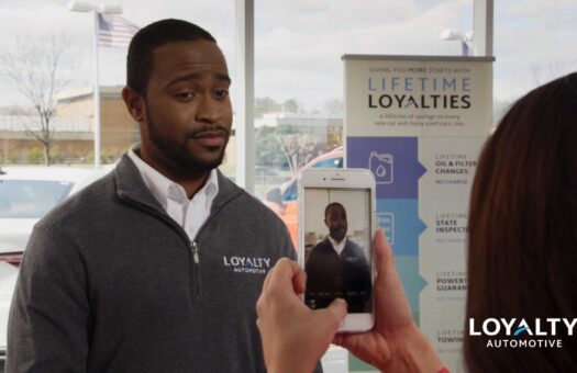 Car salesperson being videoed on smart phone