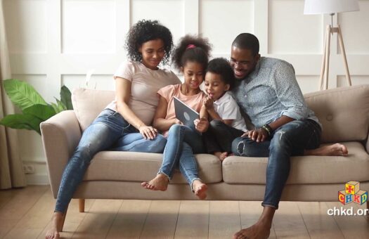 Family with kids reading on the couch