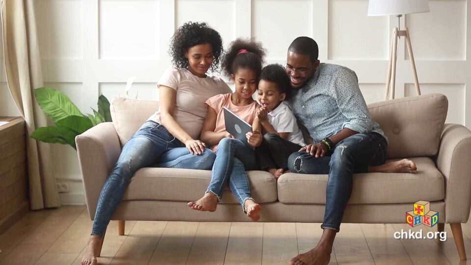 Family with kids reading on the couch