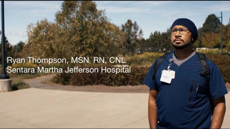 Nurse Ryan Thompson stands in front of Sentara Martha Jefferson Hospital